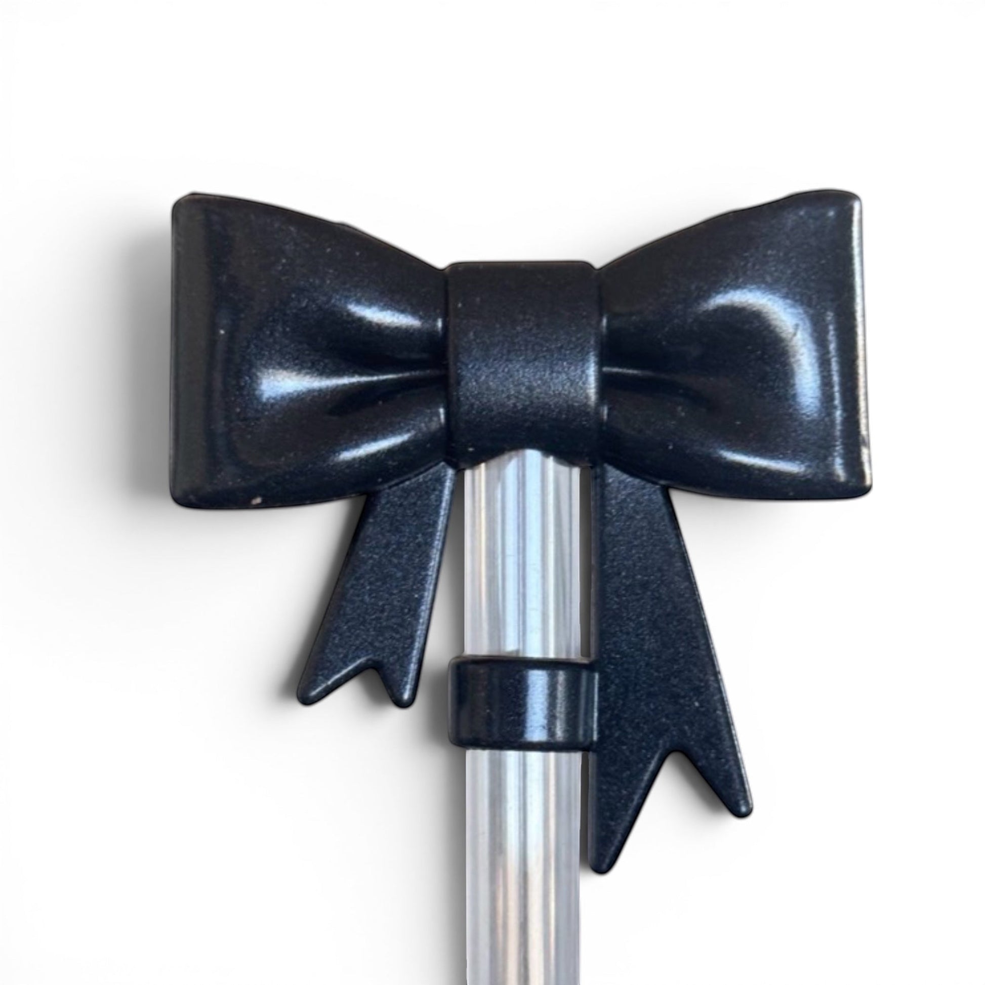 Next Nirvana black shimmer 3D bow silicone straw topper for tumblers on a clear straw