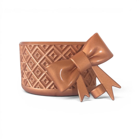 Next Nirvana bronze silicone tumbler boot with diamond texture and matching 3D bow straw topper on white background.
