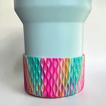 Next Nirvana Cabana Crush silicone tumbler boot with a vibrant, multi-colored wavy 3D texture on a light blue cup.