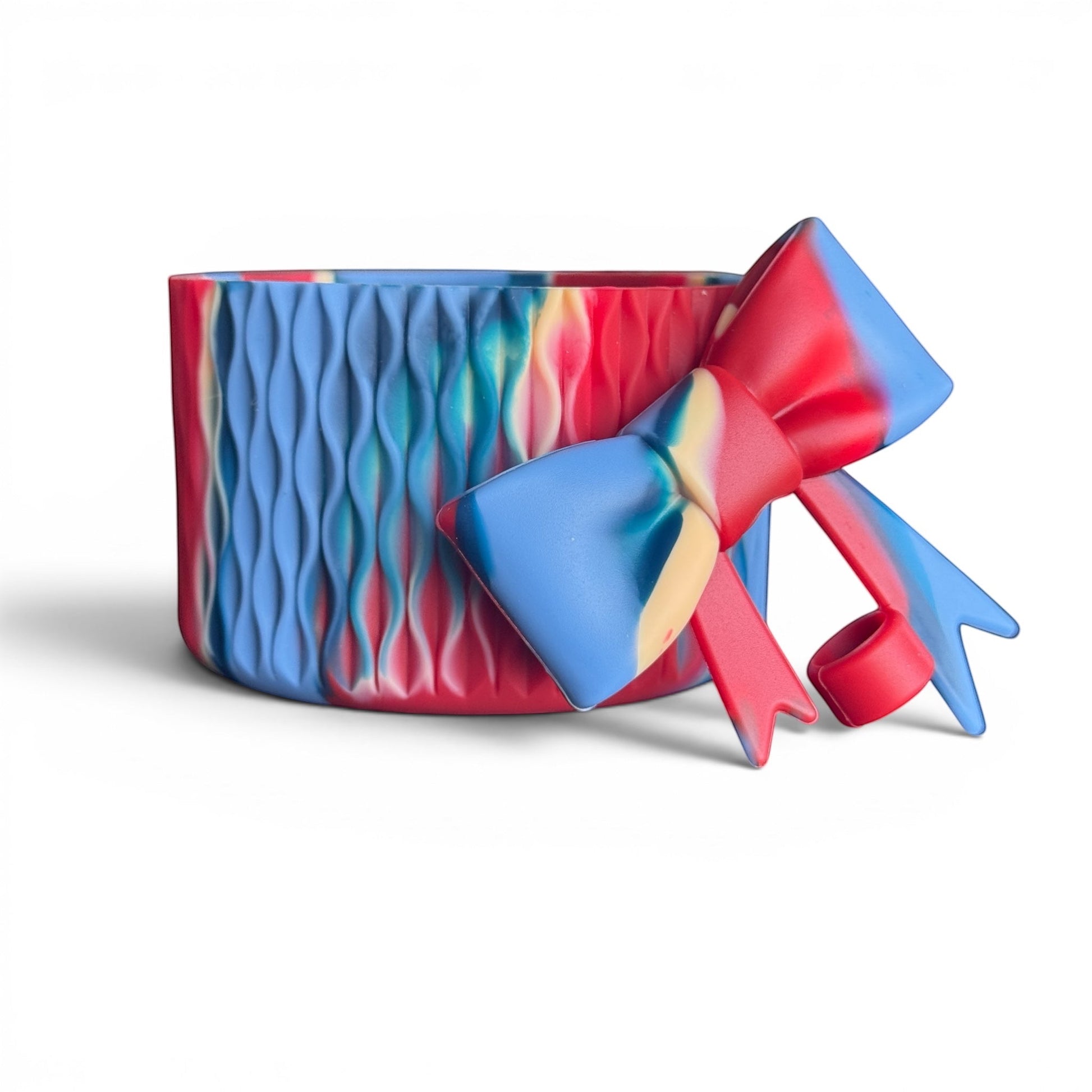 Next Nirvana Firecracker Bay silicone tumbler boot and 3D bow straw topper in a red, blue, and cream marbled pattern.