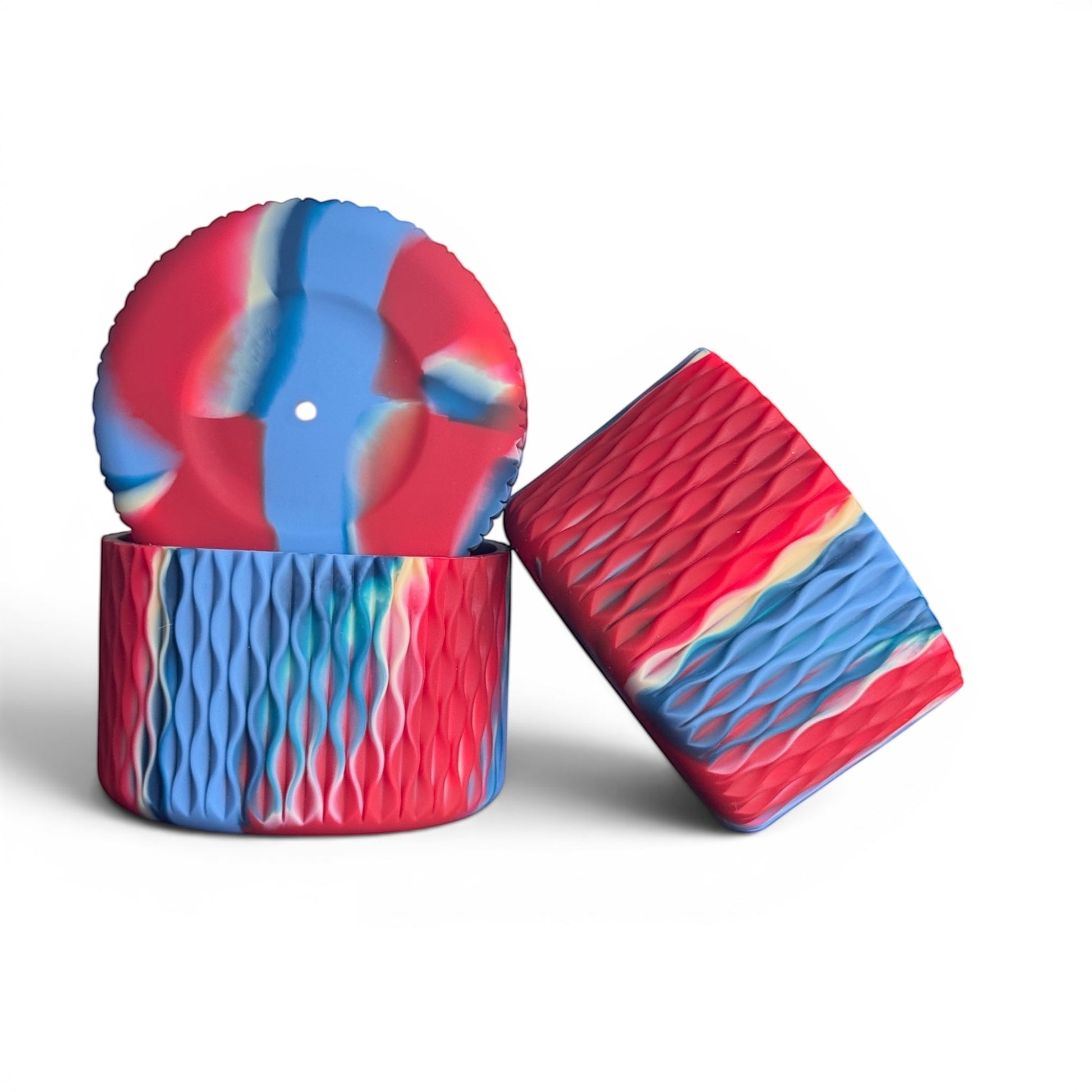 Next Nirvana Firecracker Bay silicone tumbler boot and straw topper set with red, blue, and white wavy 3D texture.
