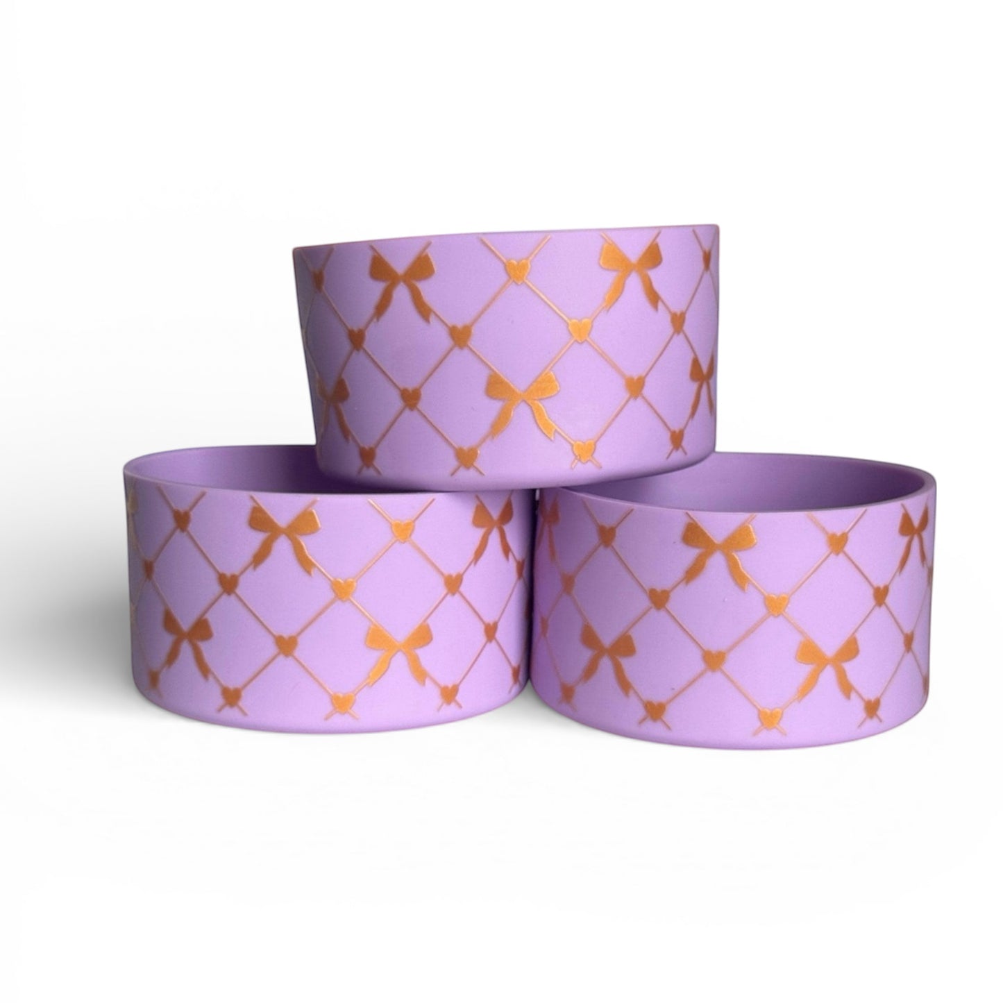 Next Nirvana lavender silicone tumbler boot featuring a gold criss-cross bow and heart pattern for protective cup base
