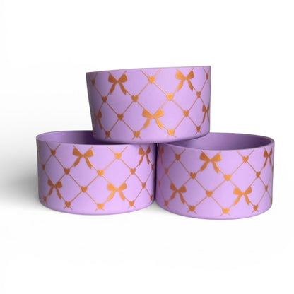Next Nirvana lavender silicone tumbler boot featuring a gold criss-cross bow and heart pattern for protective cup base