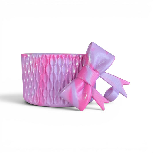 Next Nirvana lavender and pink marbled silicone tumbler boot with matching 3D bow straw topper for drinkware protection.