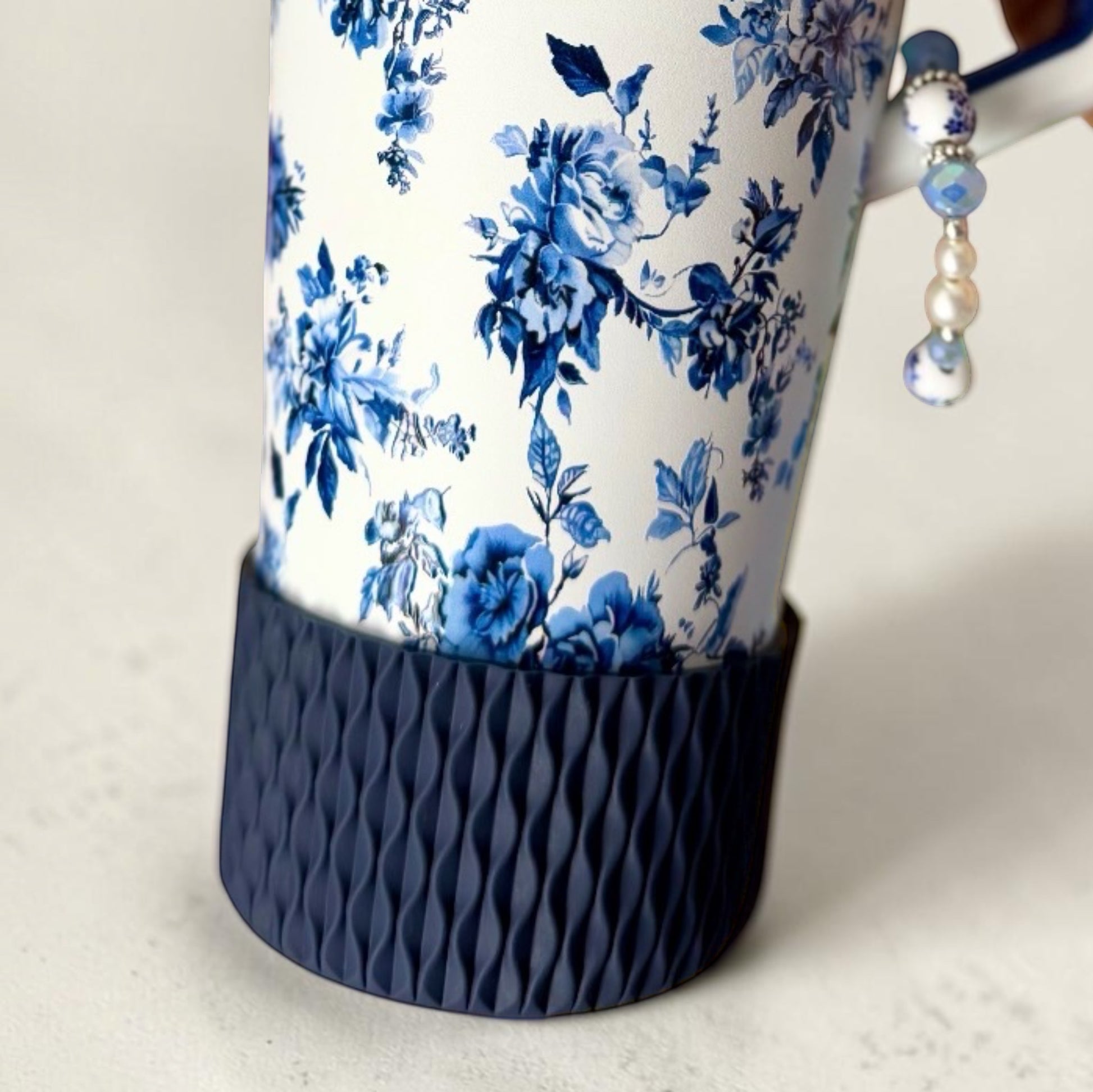 Next Nirvana navy silicone tumbler boot with a 3D wave texture on a floral patterned tumbler.