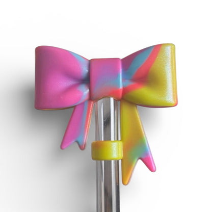 Next Nirvana 90s neon pop shimmer silicone 3D bow straw topper in pink, blue, and yellow swirl design