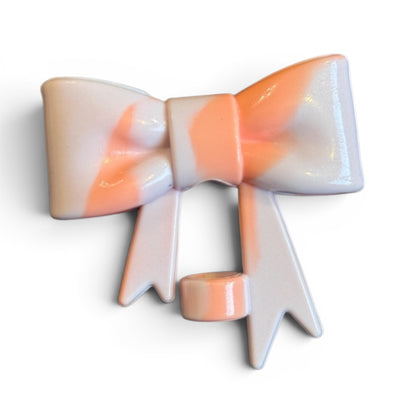 Next Nirvana orchid shimmer 3D silicone bow straw topper with a marbled peach and white finish.