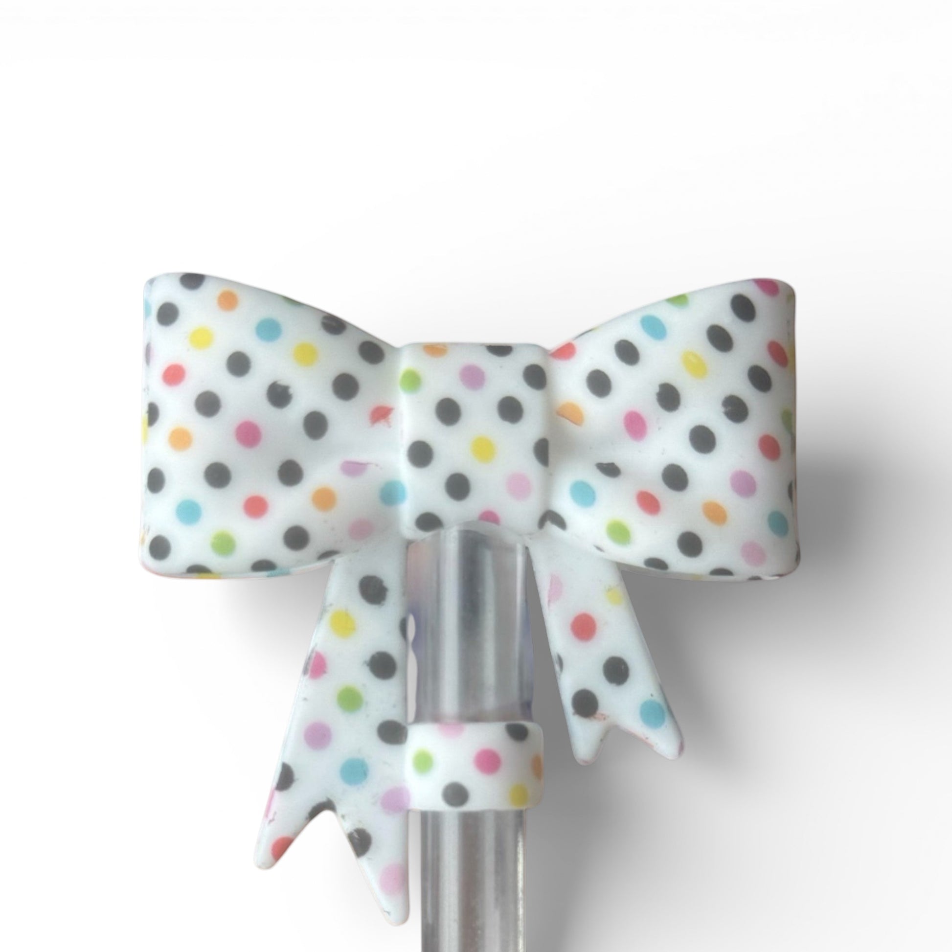 Next Nirvana silicone straw topper featuring a 3D bow design with colorful polka dots for 10mm reusable straws