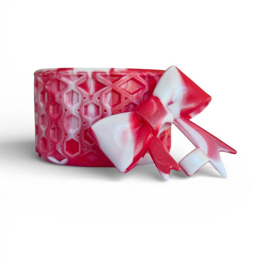Next Nirvana red and white shimmer waffle-textured silicone tumbler boot with a matching 3D bow straw topper.