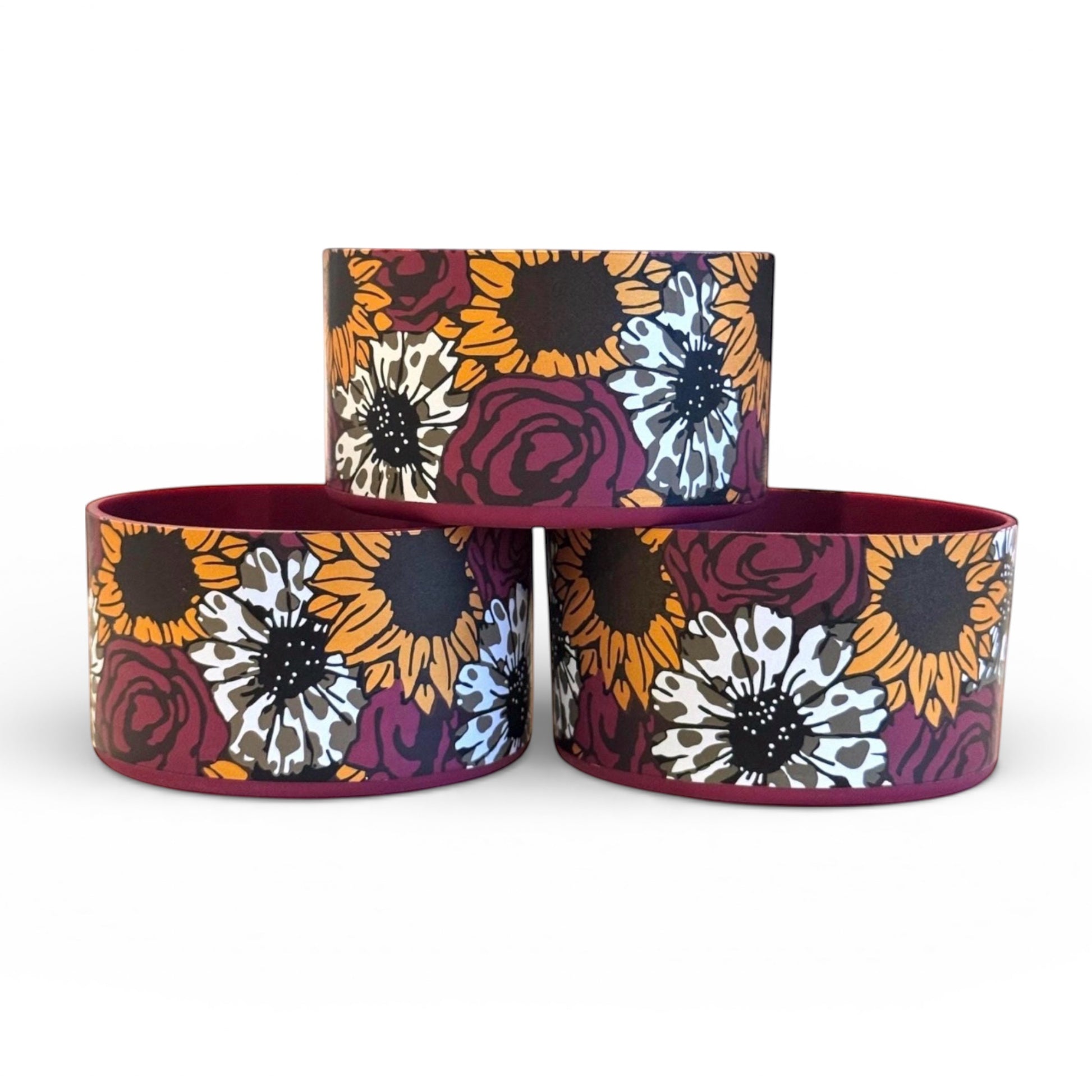 Next Nirvana Sangria Gold silicone tumbler boot with a floral pattern in burgundy, orange, and white for Stanley cups.