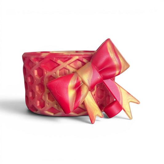 Next Nirvana Scarlet Afterglow waffle-textured silicone tumbler boot with a decorative red and gold bow accessory.