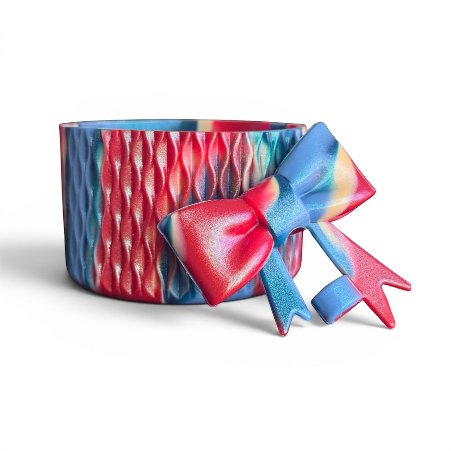 Next Nirvana silicone tumbler boot and 3D bow straw topper in a red, blue, and yellow shimmer wave pattern.