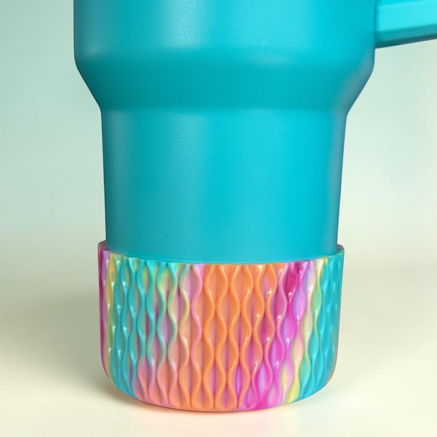 Next Nirvana silicone tumbler boot with a 3D wave texture in a multi-color shimmer finish on a teal cup.
