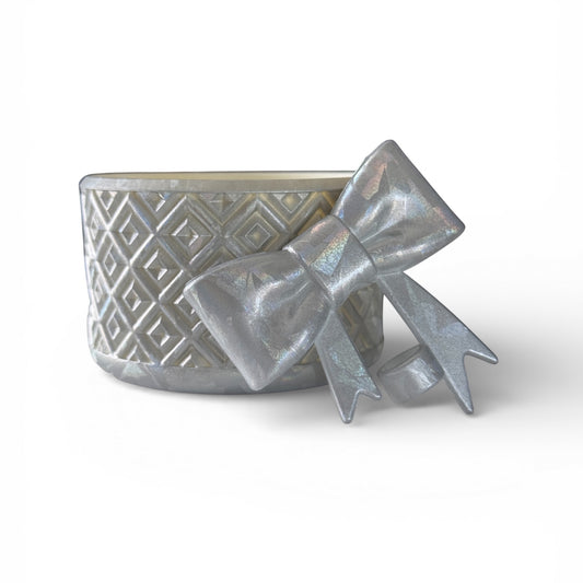 Next Nirvana silver diamond-pattern silicone tumbler boot with a matching 3D bow straw topper on a white background.