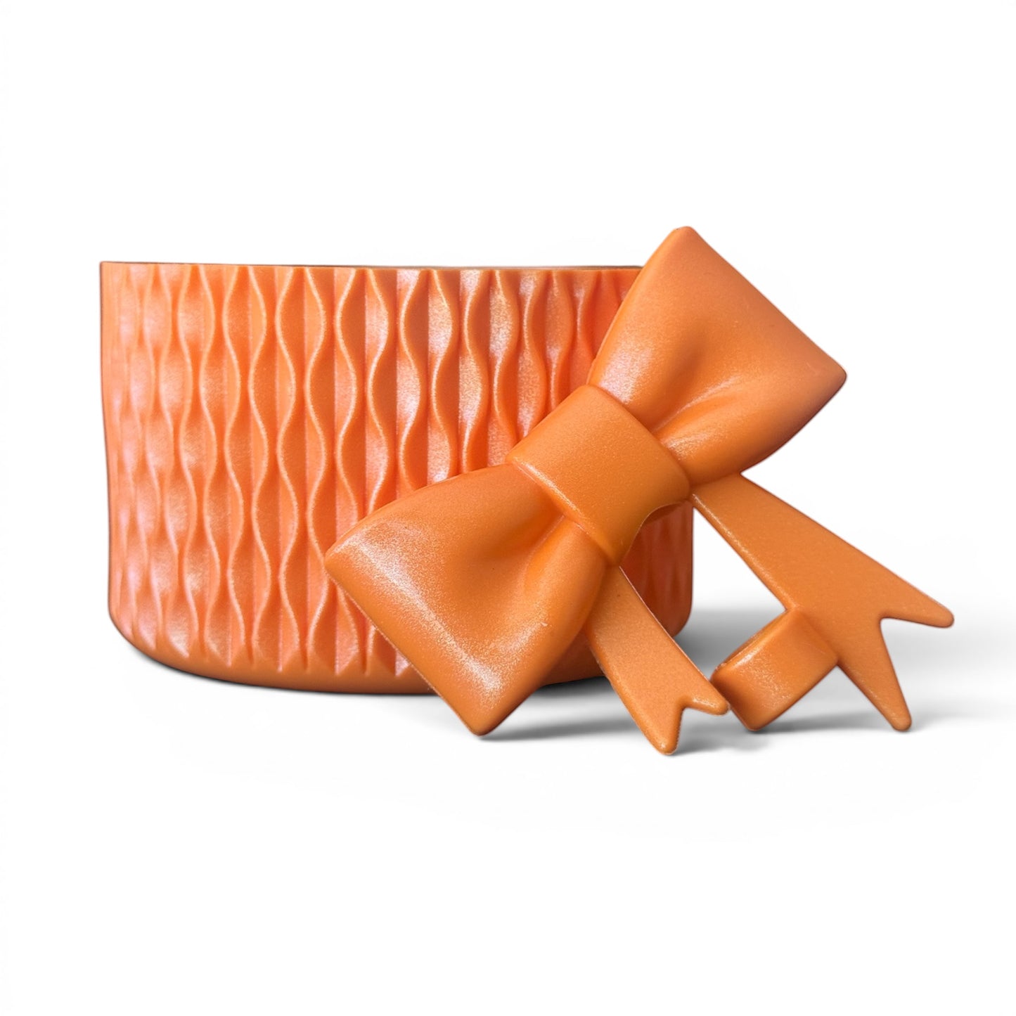 Next Nirvana tangerine shimmer silicone tumbler boot with matching 3D bow straw topper, featuring a textured wave design